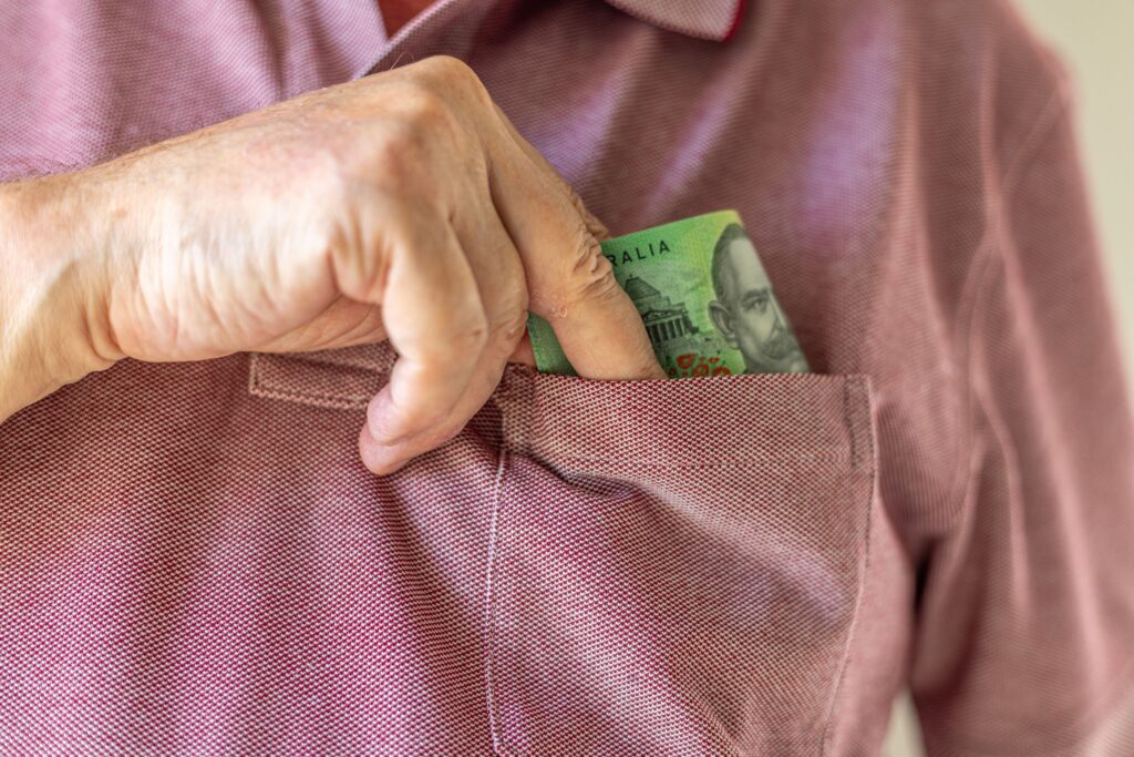 Man putting a hundred dollar bill into shirt pocket