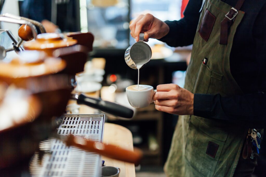Barista making a coffee in a busy cafe