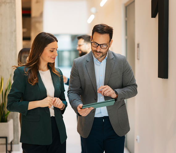 Business professionals reviewing project information while walking through an office
