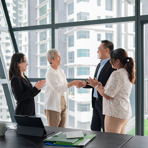 Business professionals celebrating a successful partnership in an office