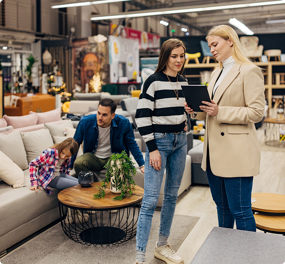 Customers discussing furniture options with a retail specialist