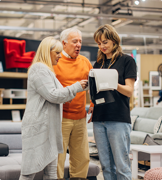 Customers reviewing furniture options with a store specialist