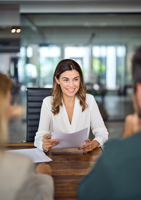 Professional reviewing documents with clients during a business discussion