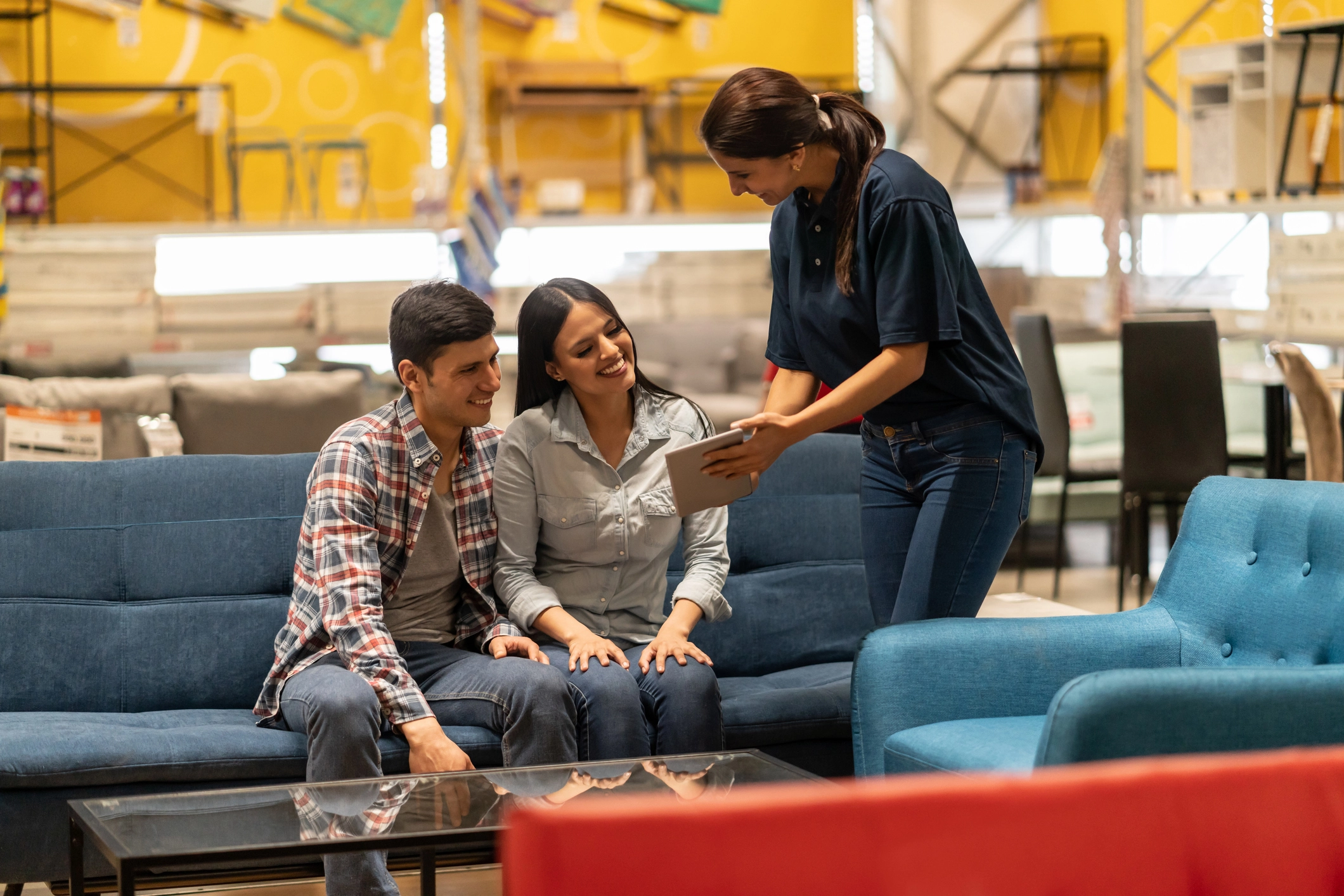 Retail professionals assisting customers with furniture selection