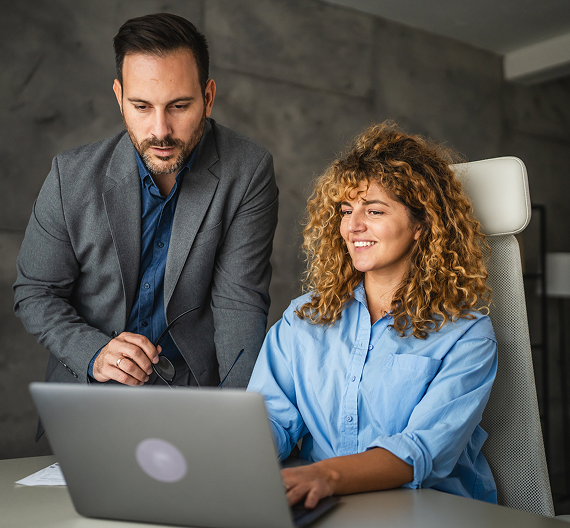 Business professionals reviewing work together using a laptop