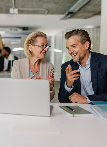 Business colleagues discussing a project while working on a laptop