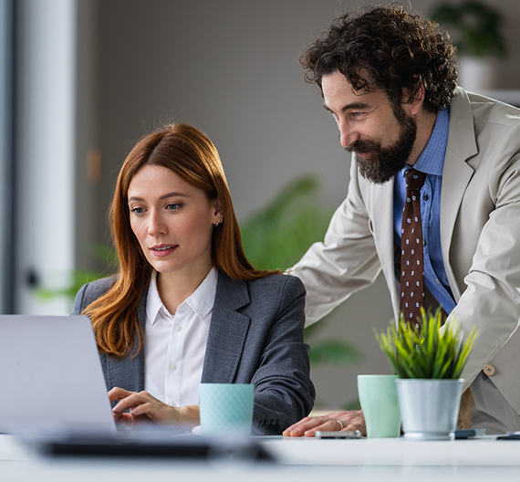 Business professionals collaborating on a project using a laptop