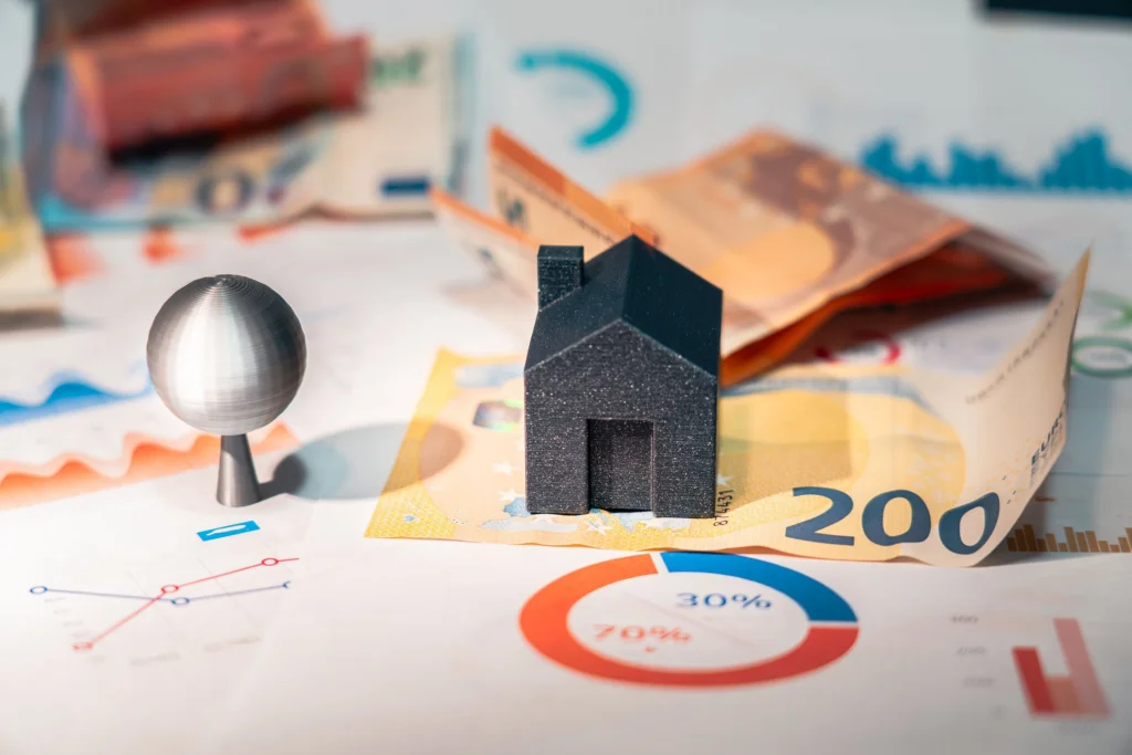 House model with euro banknotes and financial charts representing property investment